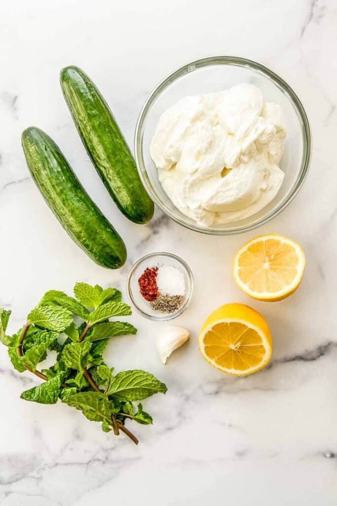 Ingredients for tzatziki on a marble background.
