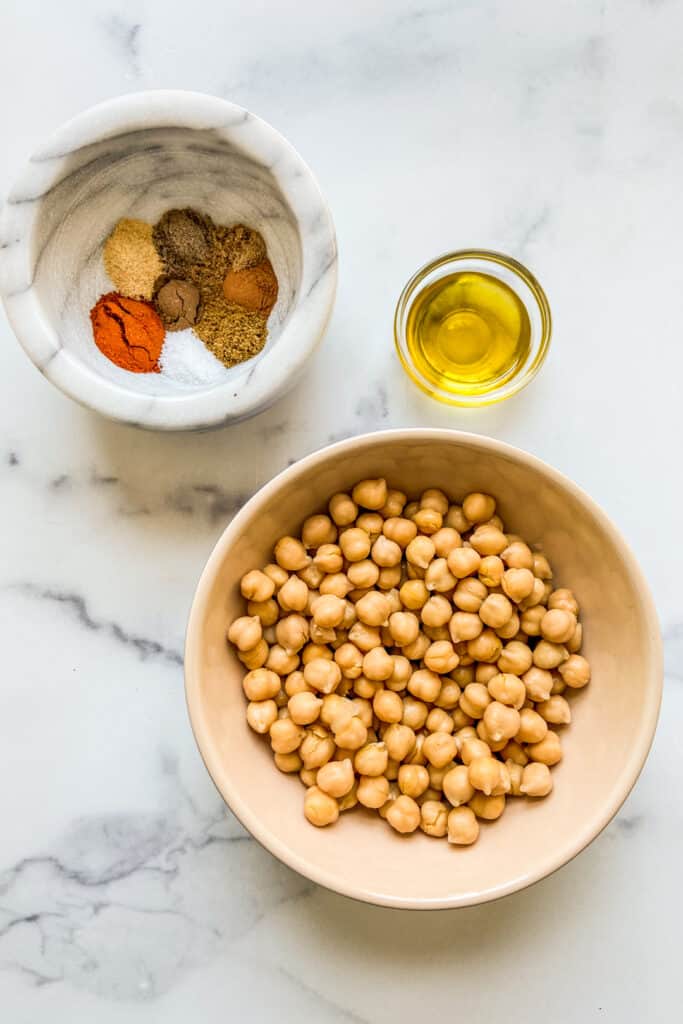 Bowls of tagine spices, chickpeas, and olive oil.