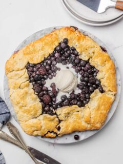 A blueberry blackberry galette with a scoop of vanilla ice cream.