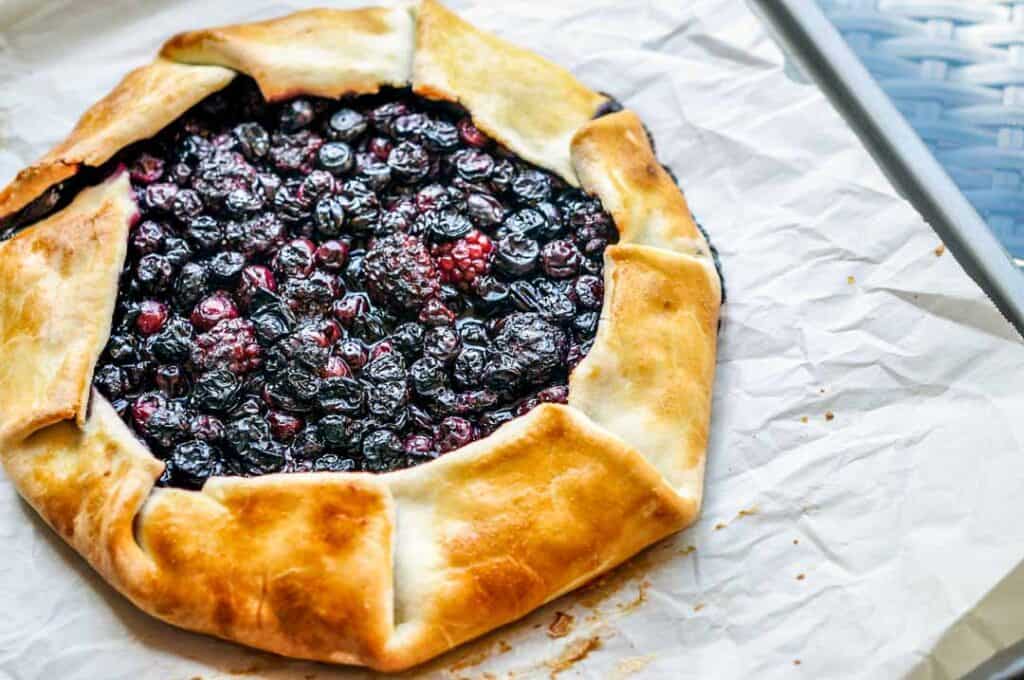 Blueberry blackberry galette on a piece of parchment paper.