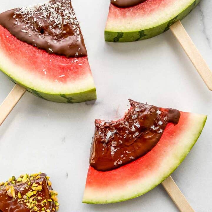 Closeup shot of watermelon triangles dipped in dark chocolate.