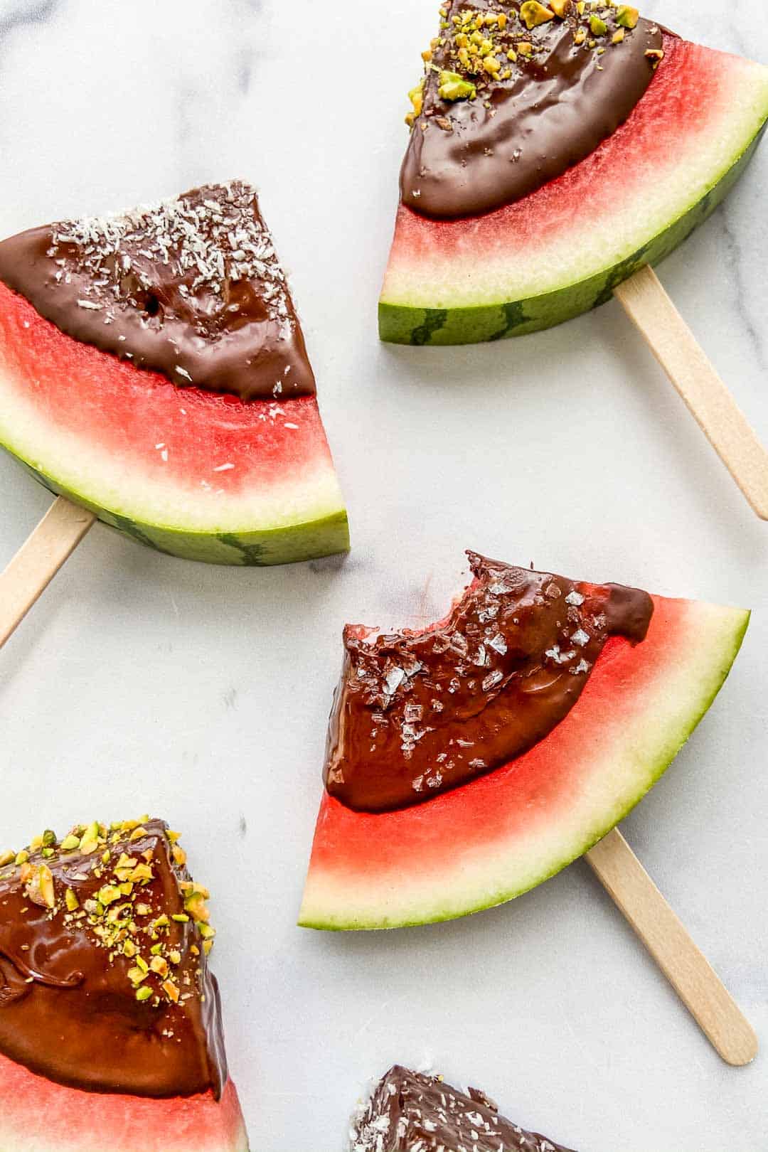 Closeup shot of watermelon triangles dipped in dark chocolate.