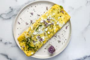 Spring omelette with goat cheese and asparagus on a white plate.