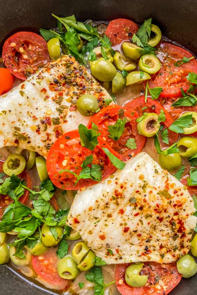 Sea bass with olives, tomatoes, and parsley.