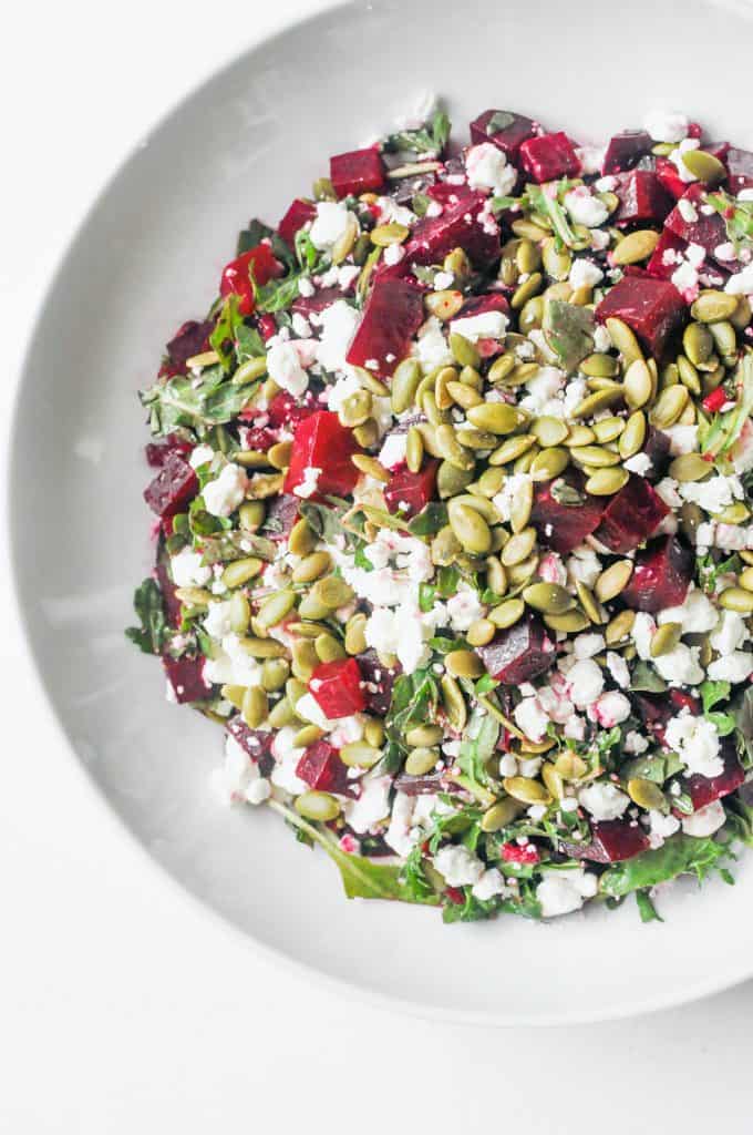 roasted beets, pepitas, arugula in a bowl