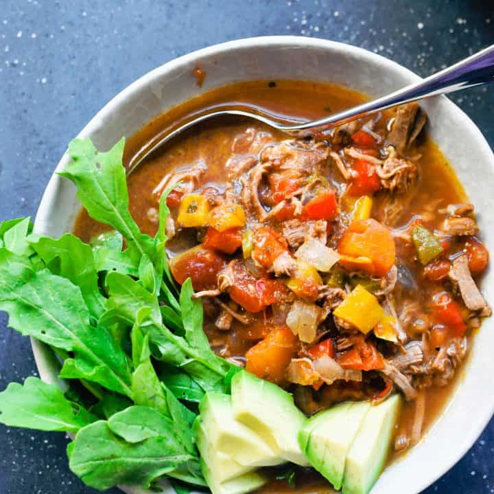 Slow cooker brisket chili with cilantro and avocado on top.