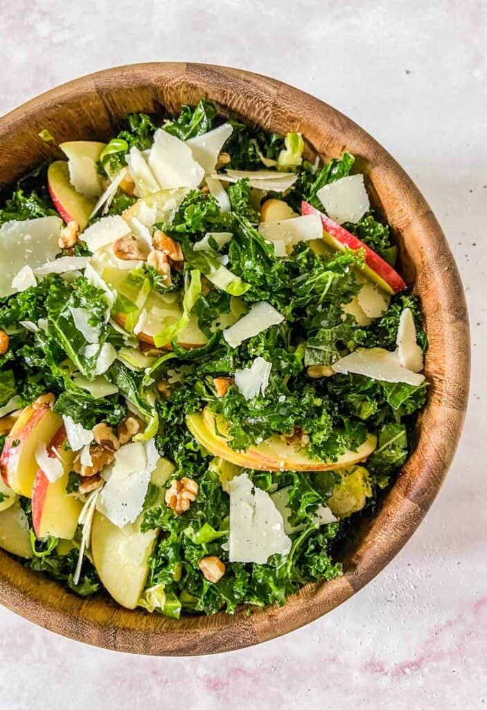 brussels sprouts kale and apple salad in a wooden bowl