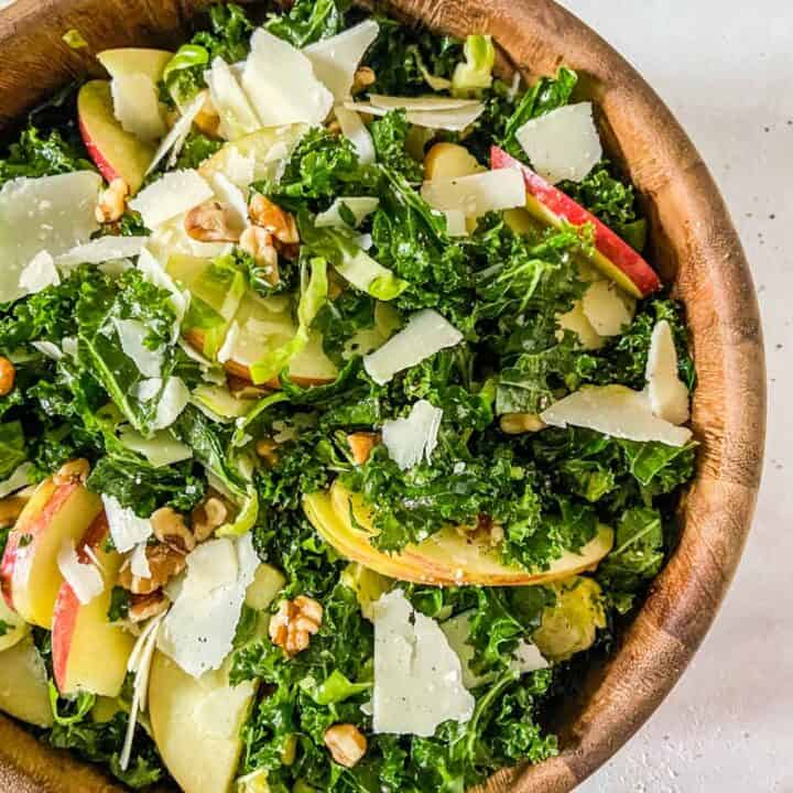 brussels sprouts kale and apple salad in a wooden bowl