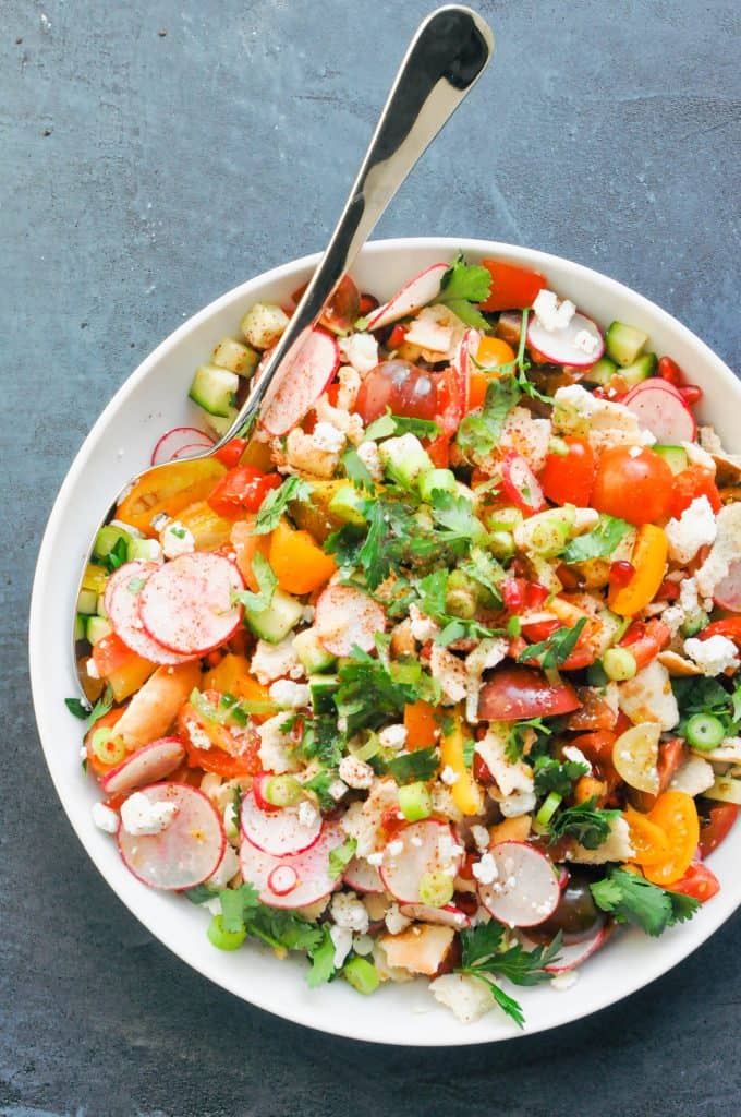 fattoush salad in a large serving bowl with a serving spoon