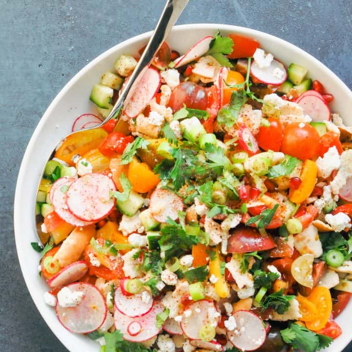 fattoush salad in a large serving bowl with a serving spoon