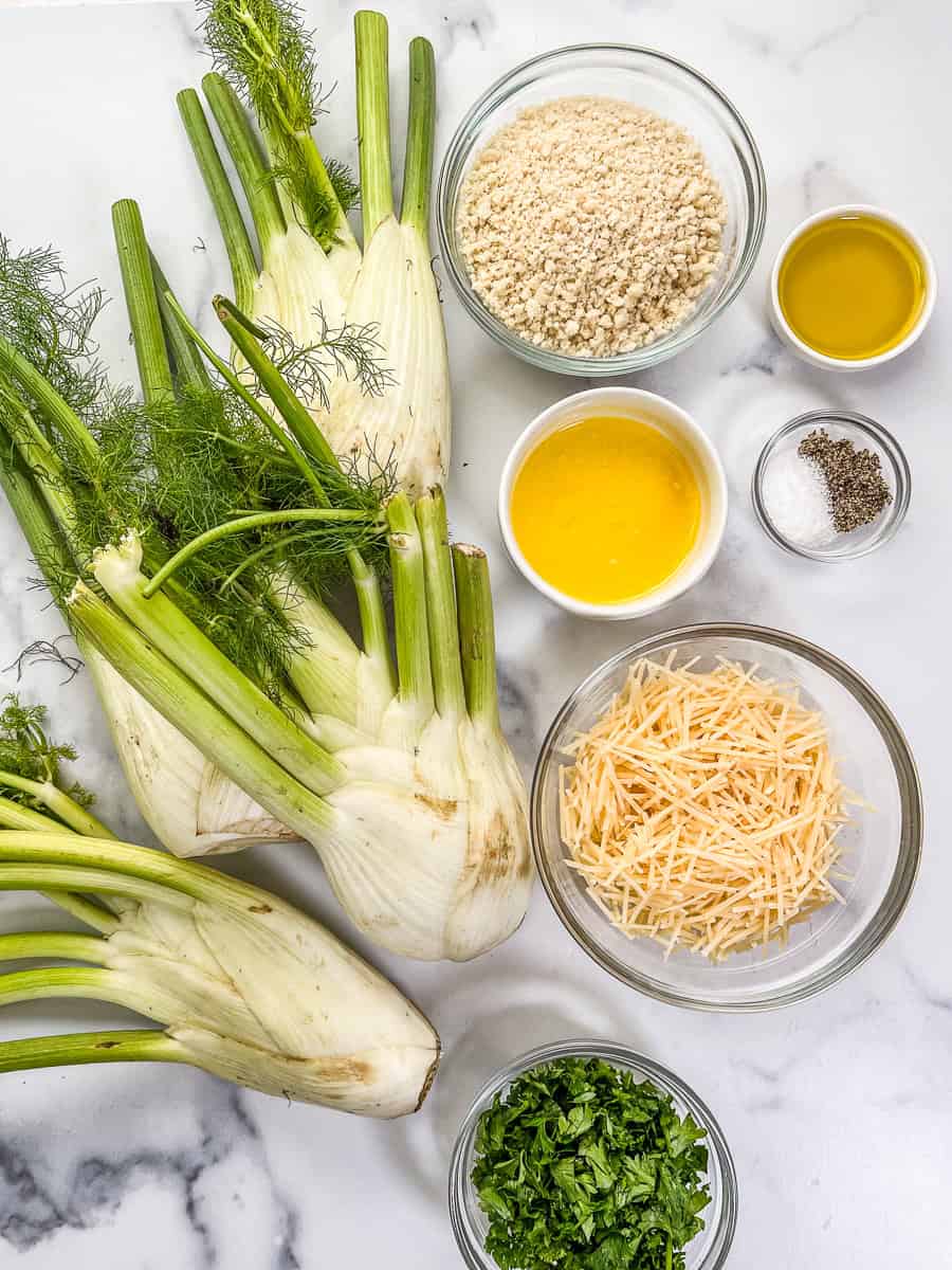 Ingredients for fennel gratin on a marble background.