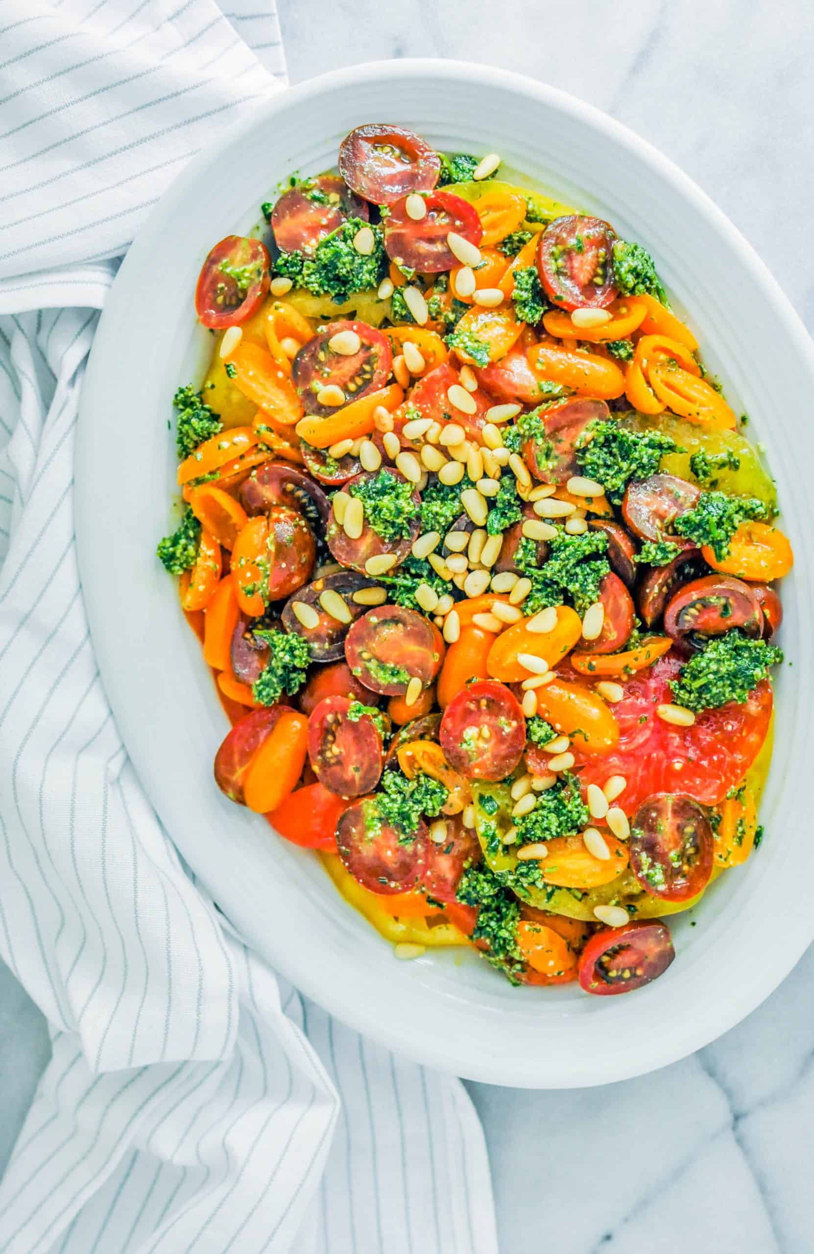 tomato tarragon salad topped with pine nuts on a platter