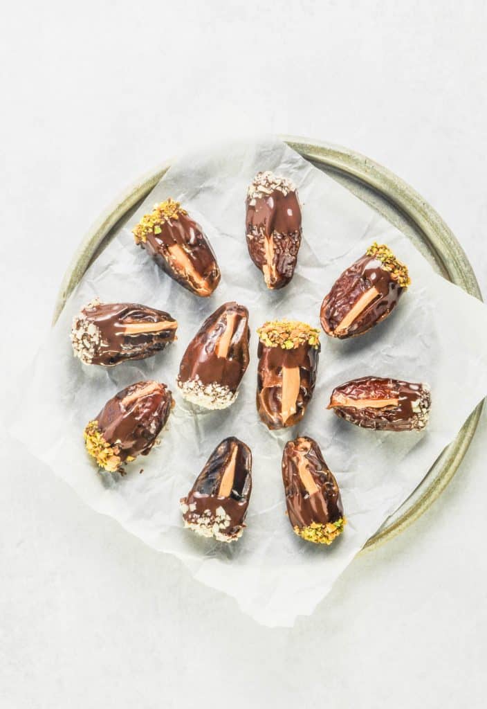 peanut butter stuffed dates covered in chocolate on a plate