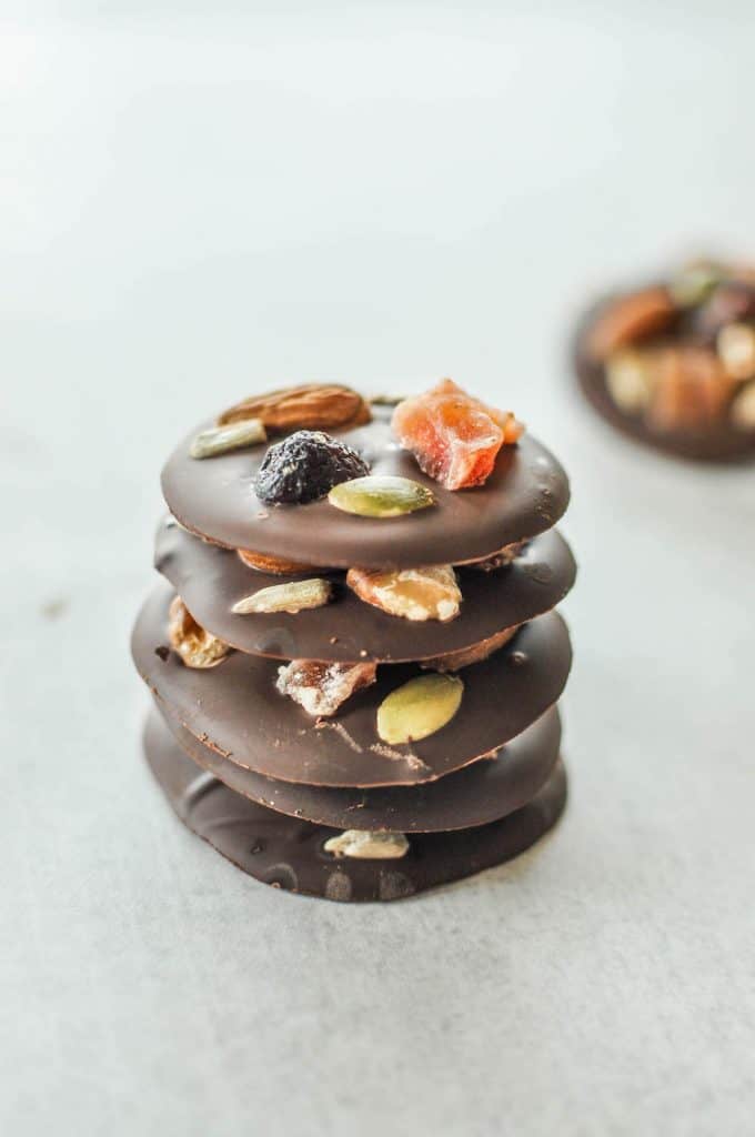 fruit and nut dark chocolate bites stacked on top of each other