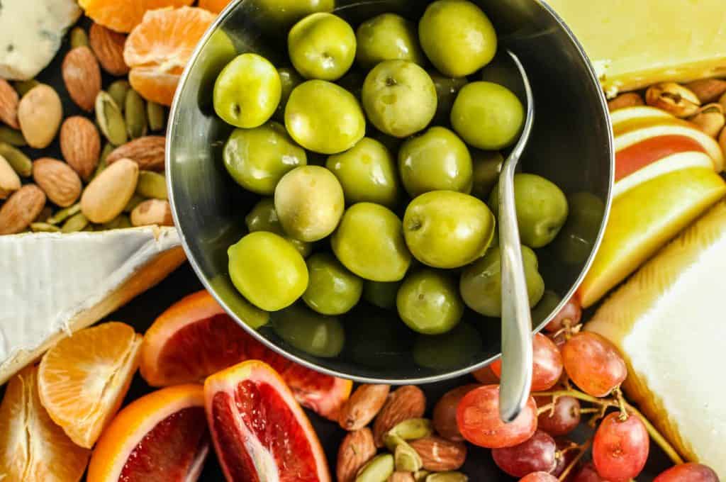 closeup of green olives on appetizer board