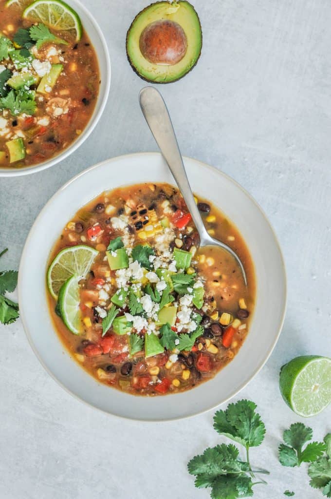 Mexican veggie soup in a bowl with a spoon