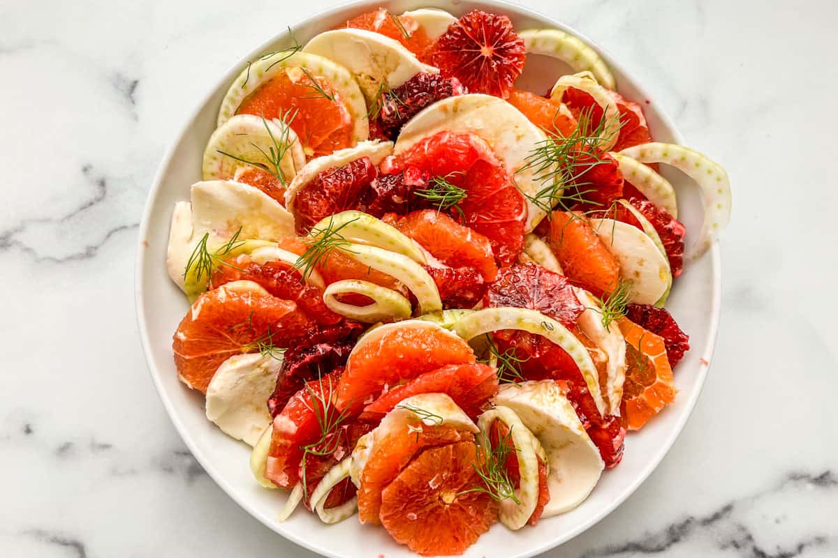 Sliced citrus, fennel, and mozzarella in a serving bowl.