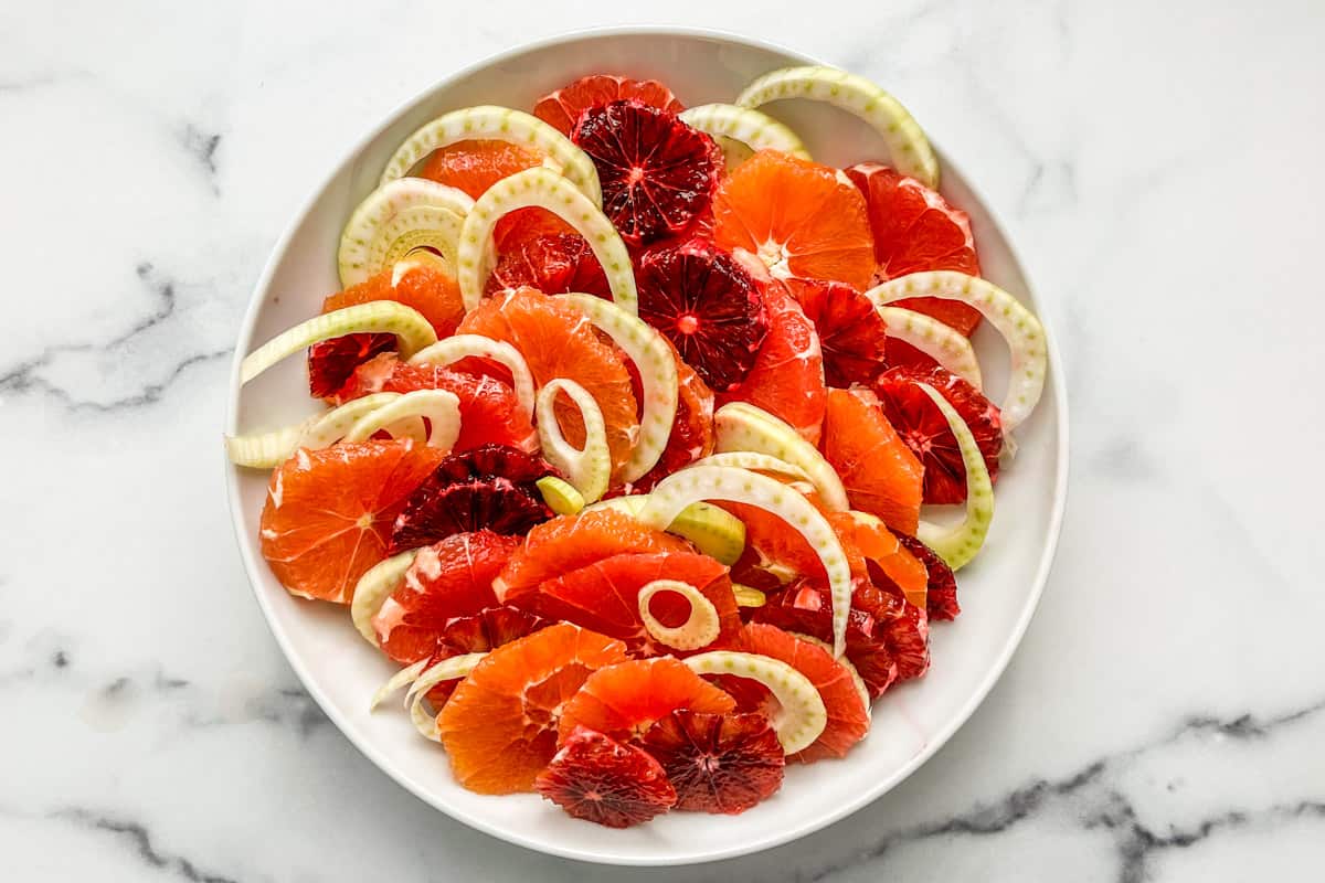 Sliced oranges and fennel in a white serving bowl.