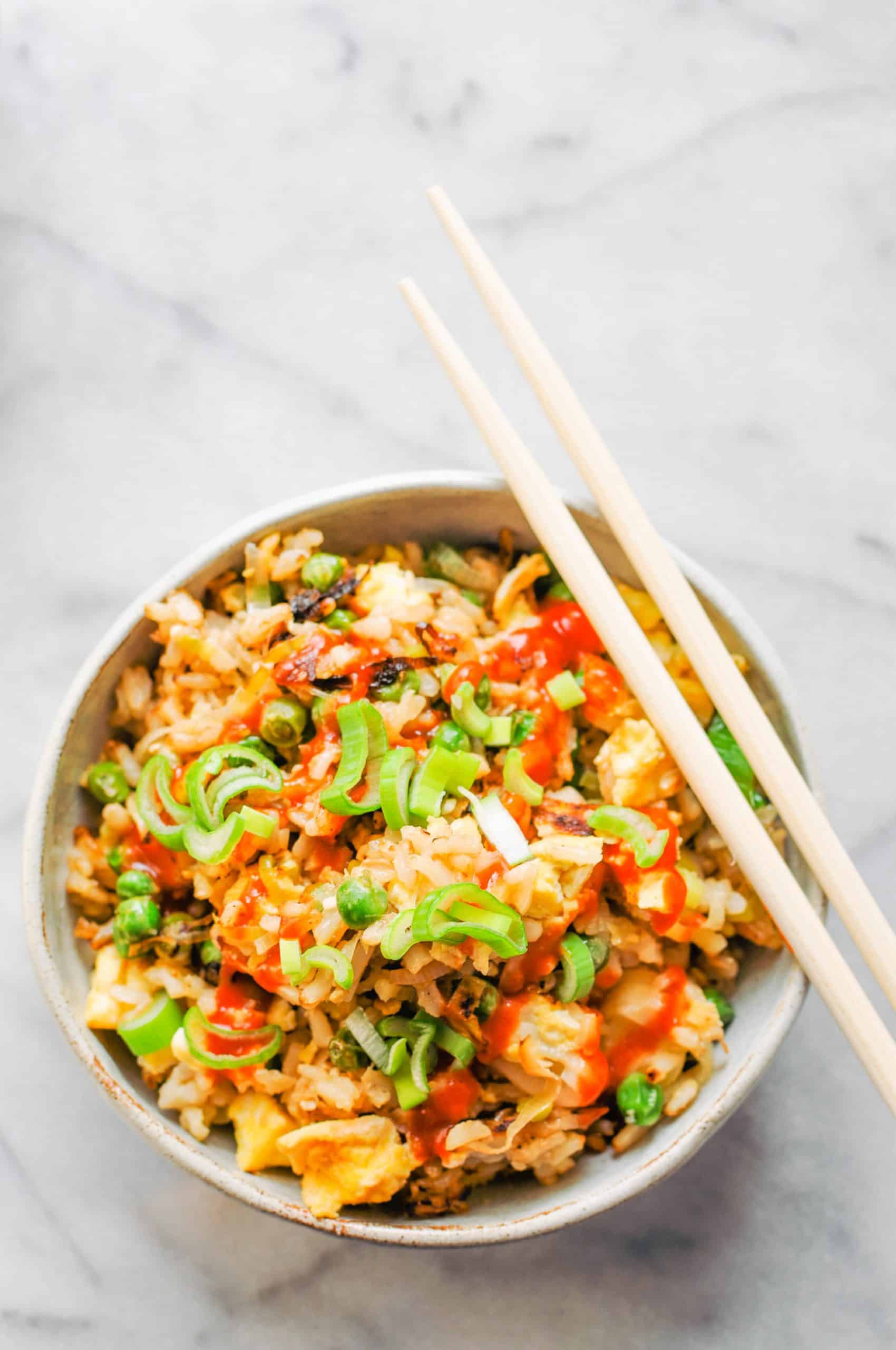 leek and pea fried rice in a bowl with chopsticks