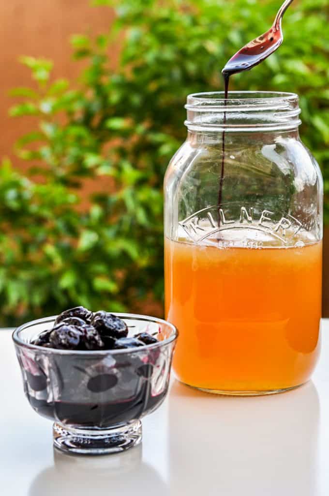 whiskey sour recipe with cherry syrup in a glass ball jar