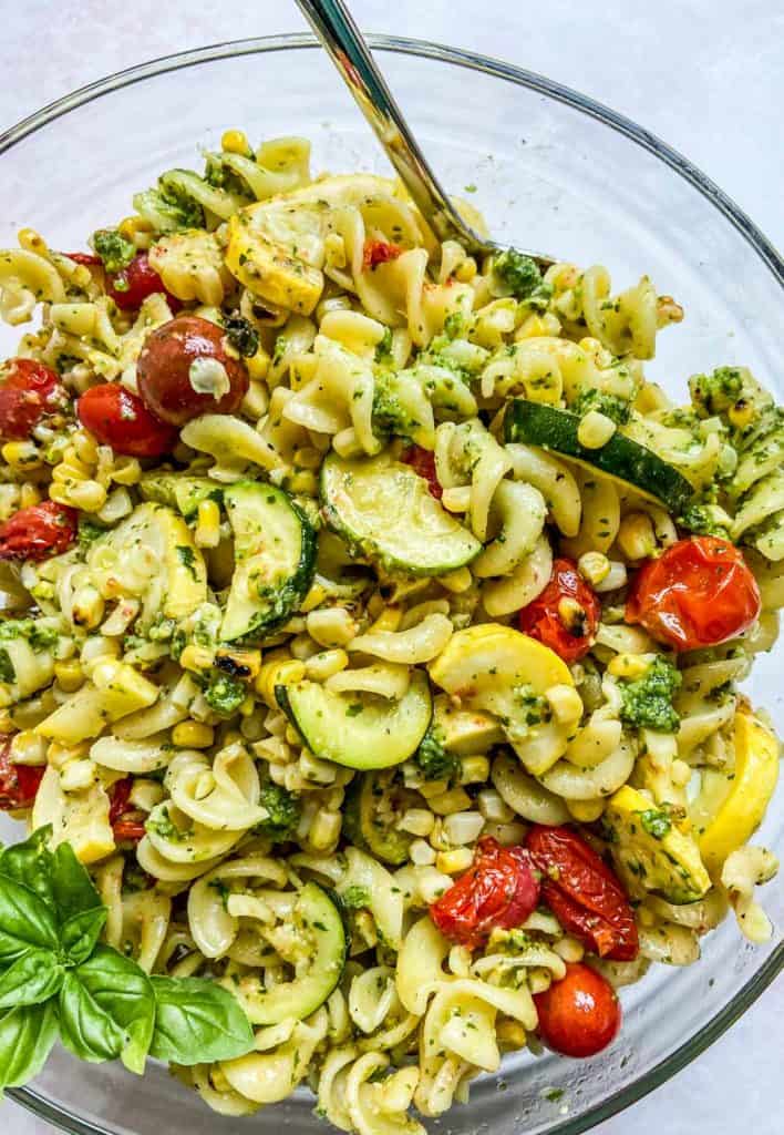 Pesto pasta salad recipe in a glass bowl.