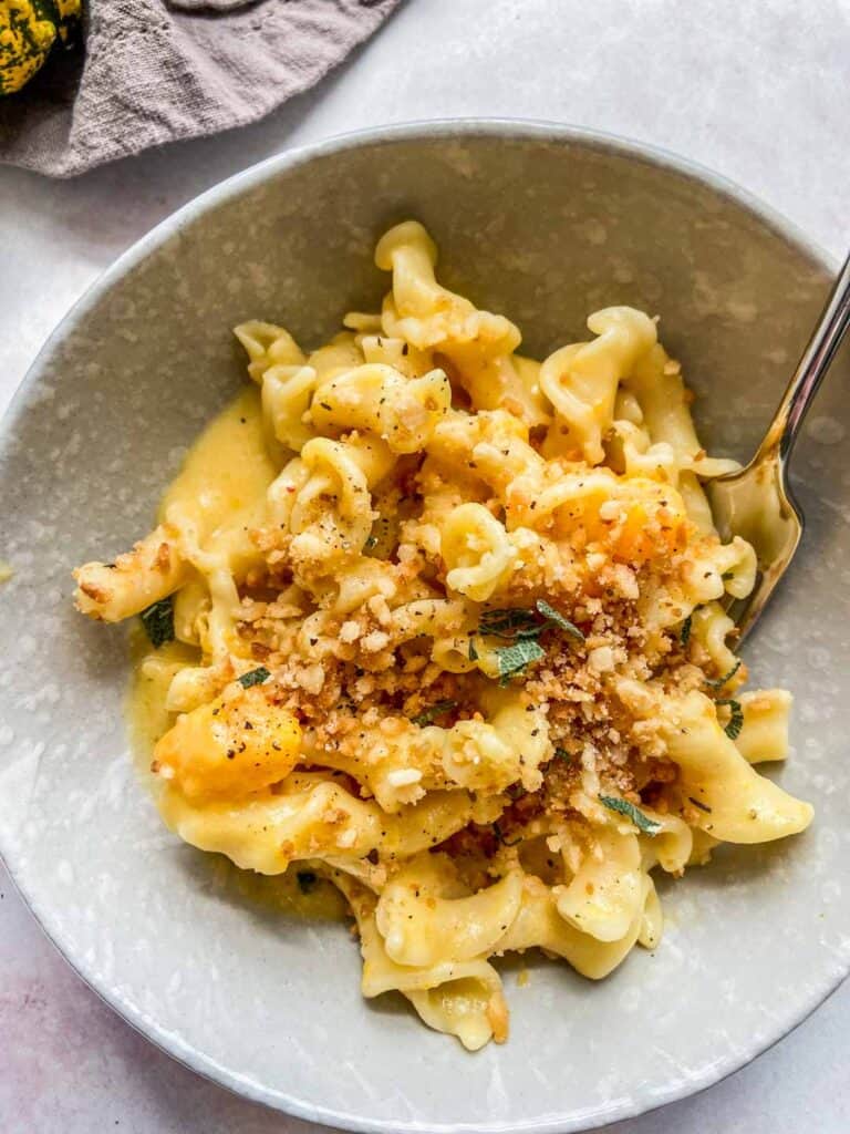 Butternut squash pasta in a bowl with a spoon.