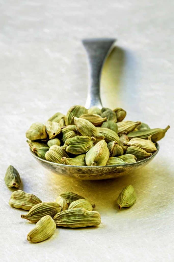 cardamom pods on a silver spoon