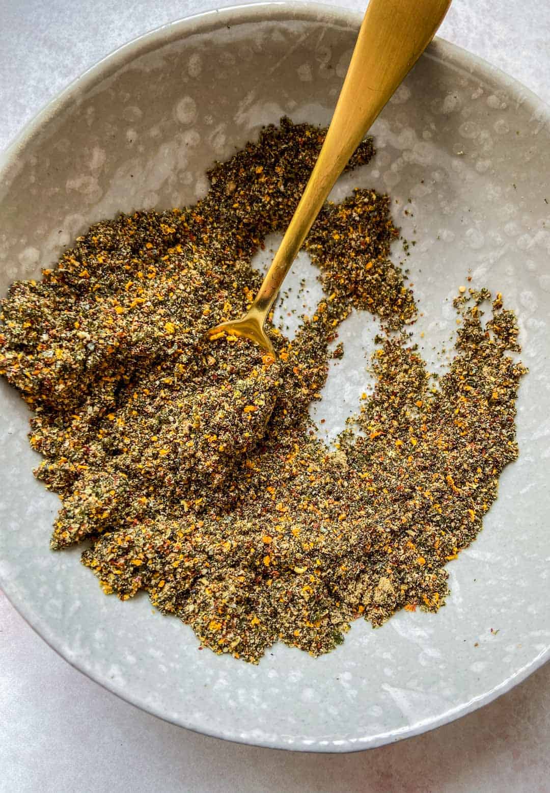 Shichimi Togarashi in a grey bowl with a spoon.