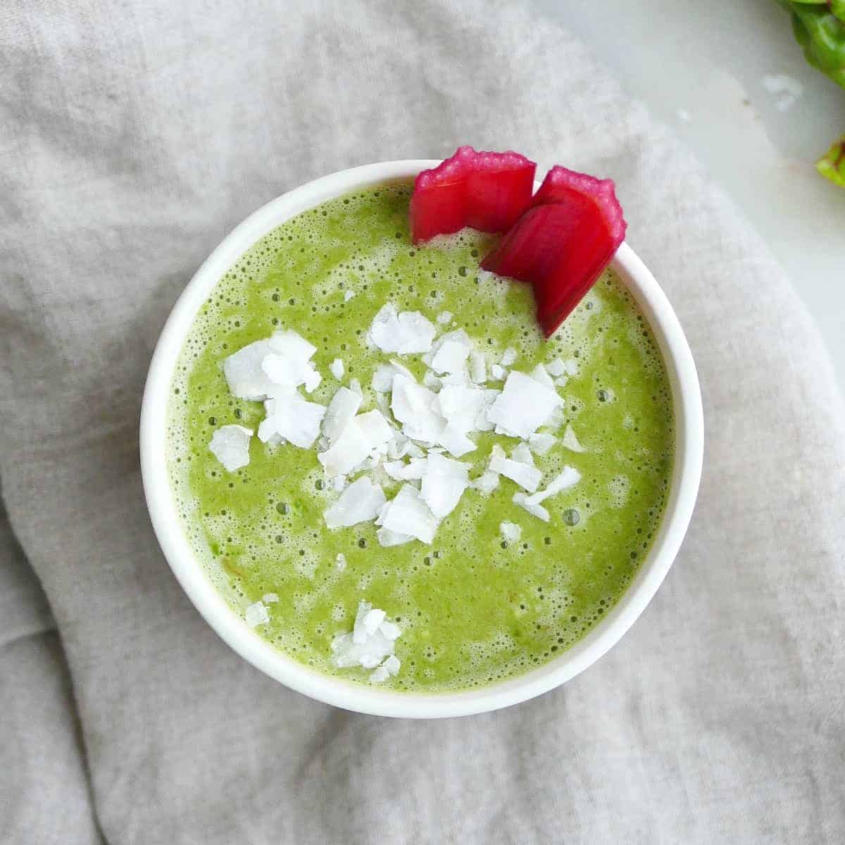 A Swiss chard smoothie in a white cup.