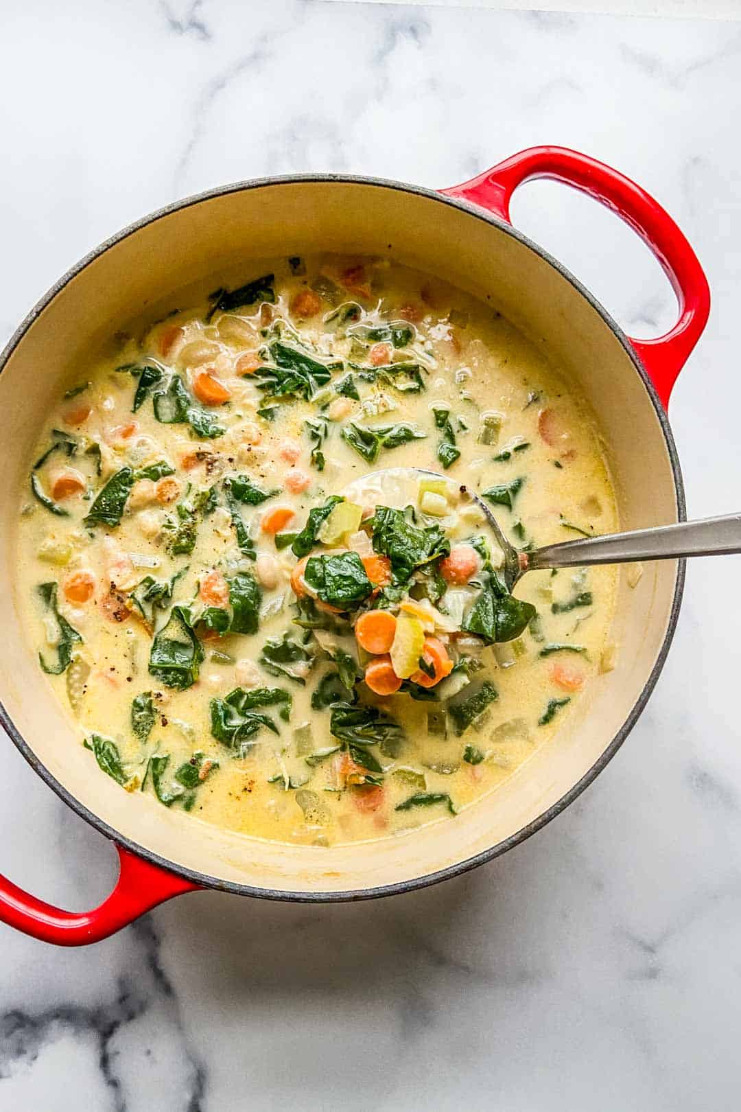 white bean soup in a dutch oven with a ladle