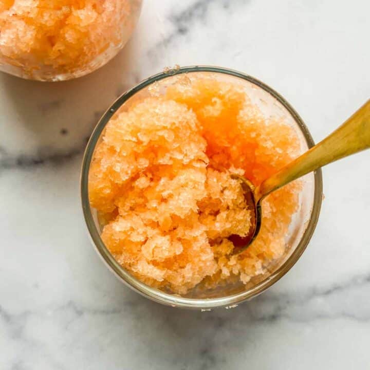 Cantaloupe granita in a wine glass with a gold spoon.