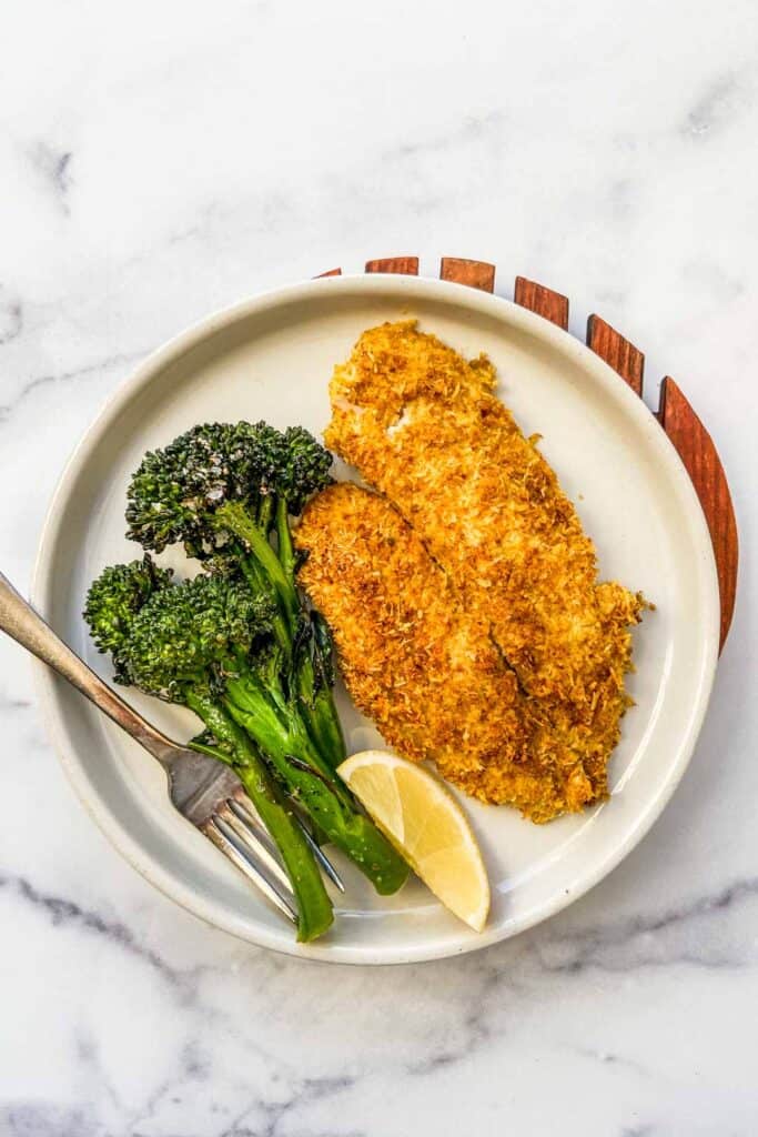 coconut crusted tilapia with broccolini on a plate