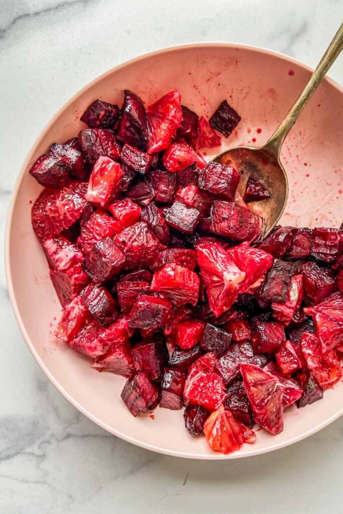 roasted beets and blood oranges in a pink serving bowl