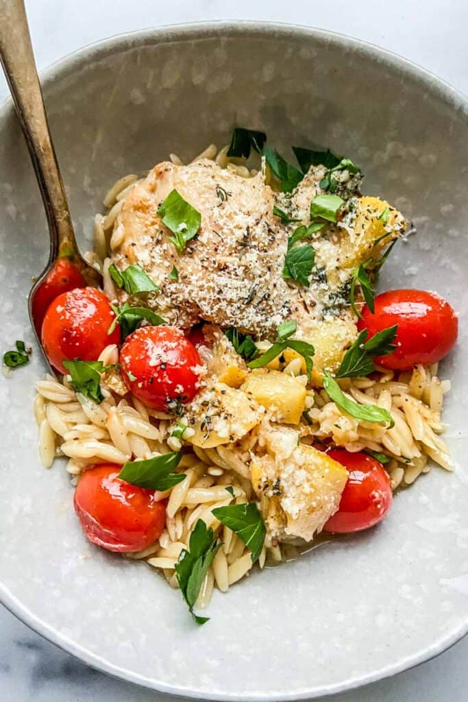 lemon chicken with orzo in a bowl with a fork.