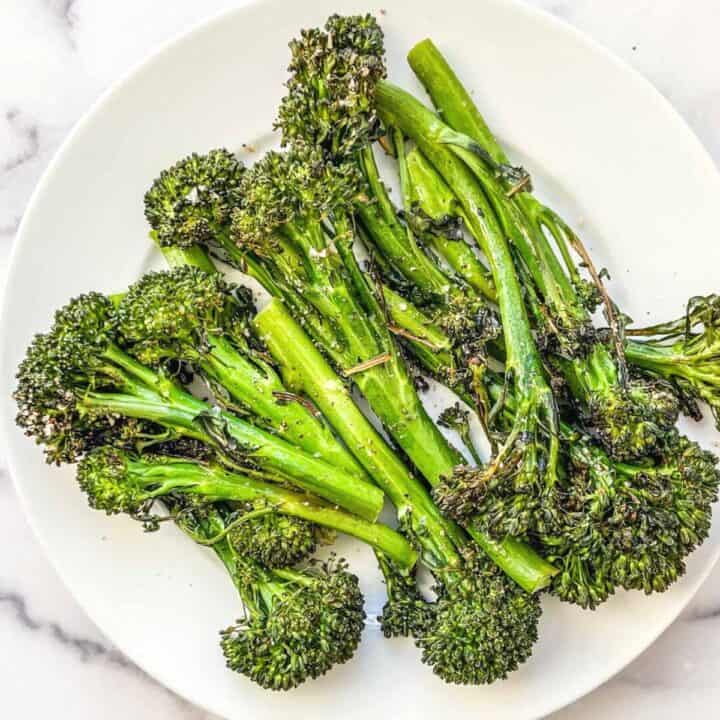 Roasted broccolini on a white plate.