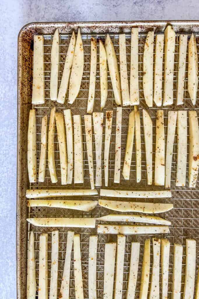 Uncooked fries on a baking sheet.