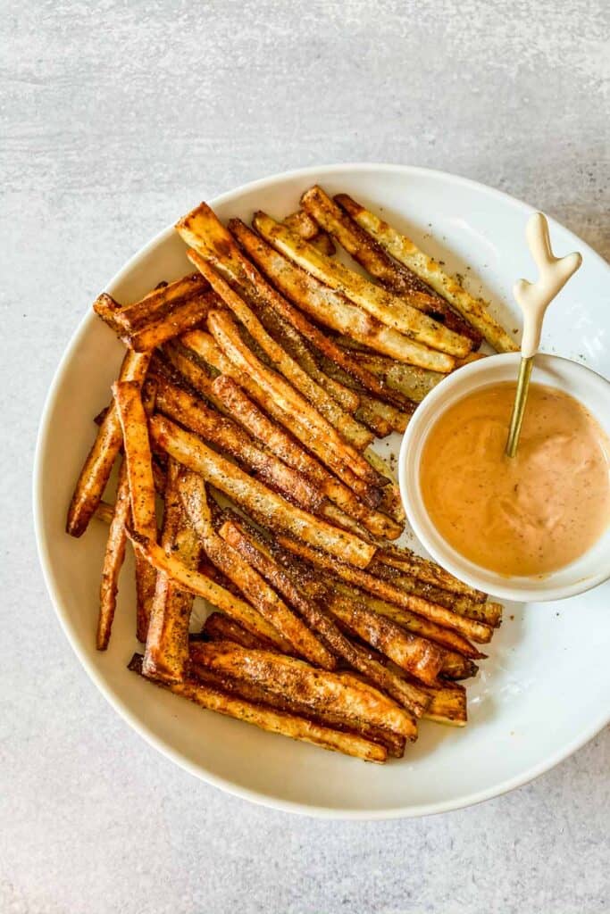 Togarashi fries in a white bowl with a side of spicy mayo. 