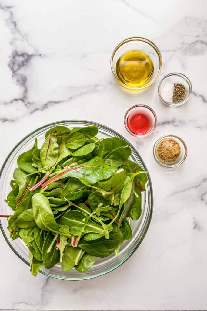 Ingredients for a green salad on a marble background.