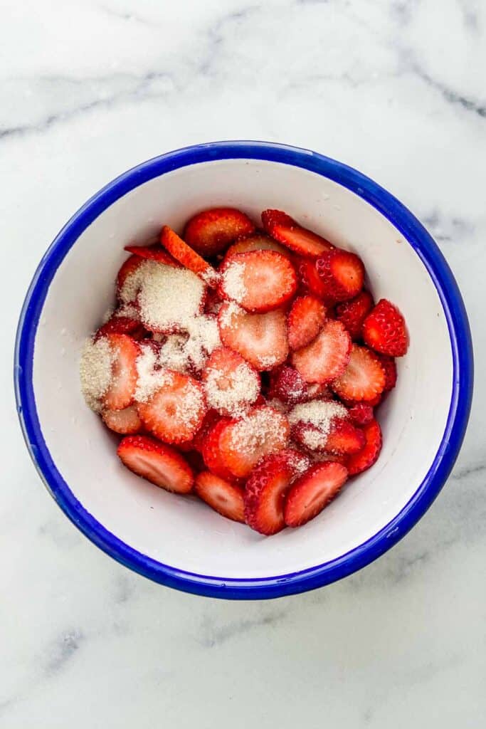 A bowl of cut strawberries with sugar and orange blossom water.