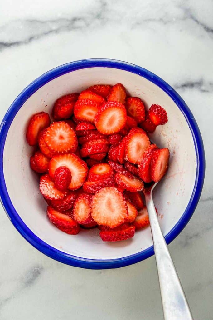 A bowl of cut strawberries with sugar and orange blossom water.