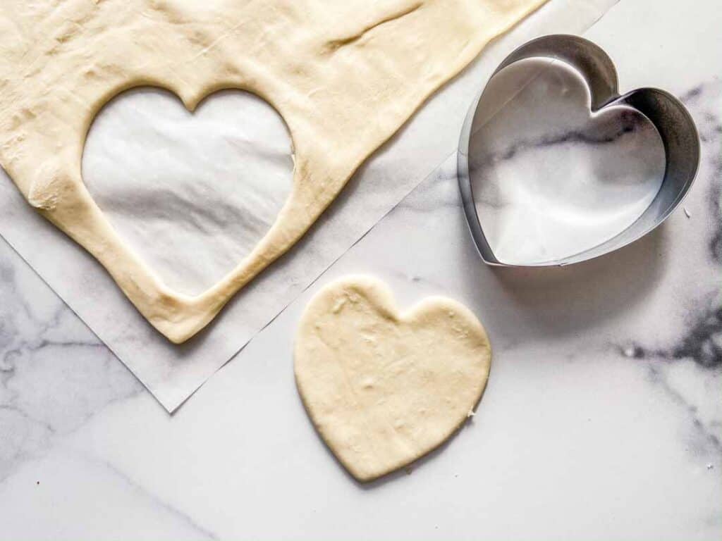 Cutting hearts from the puff pastry dough.