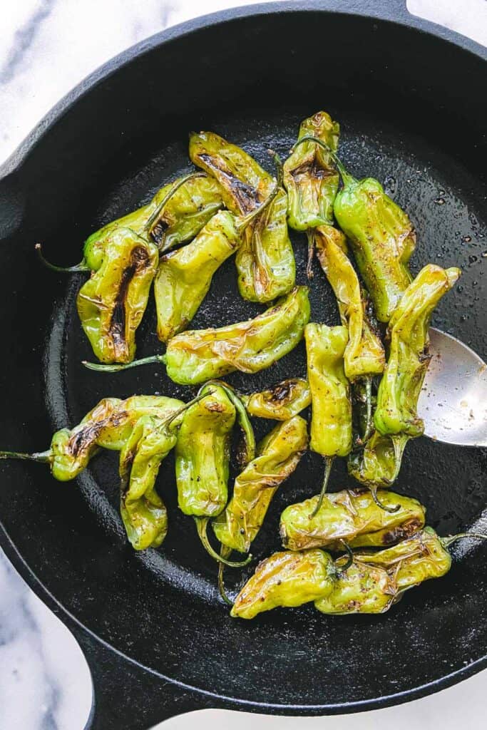 Shishito peppers in a cast iron skillet.