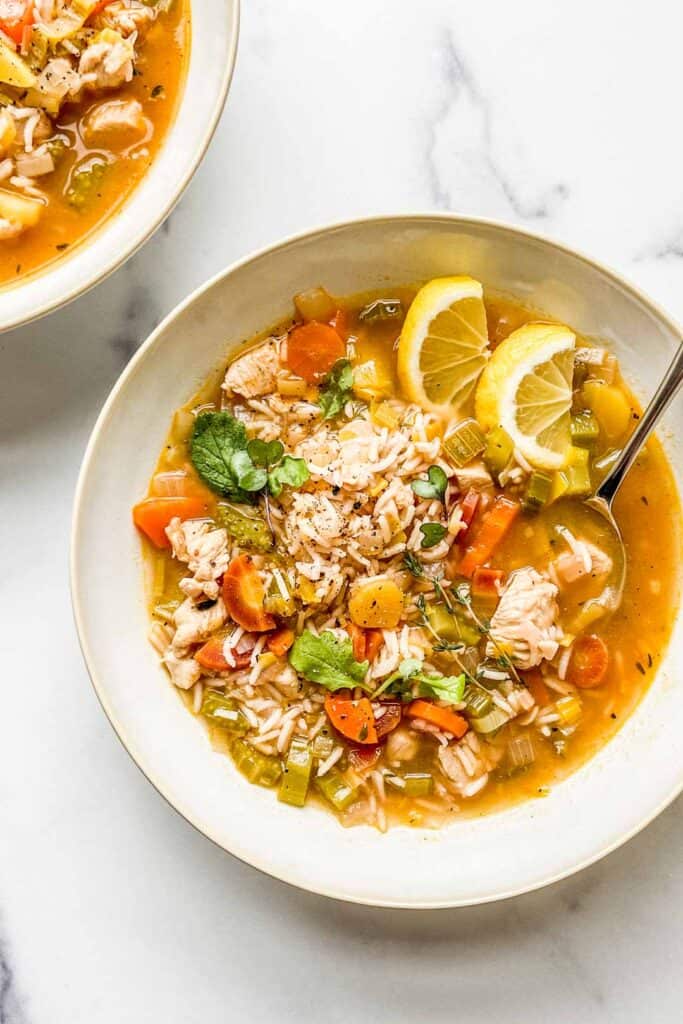 A closeup shot of a bowl of lemon chicken rice soup.