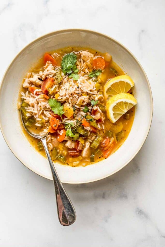 An overhead shot of a bowl of lemon chicken rice soup.