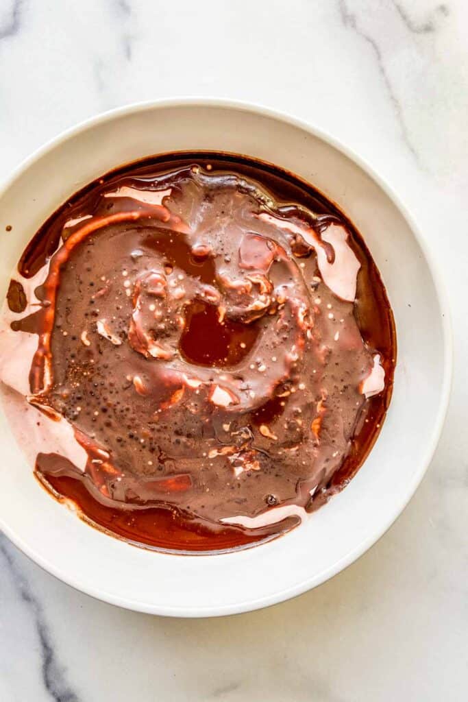 An overhead shot of magic shell hardening on a smoothie bowl.