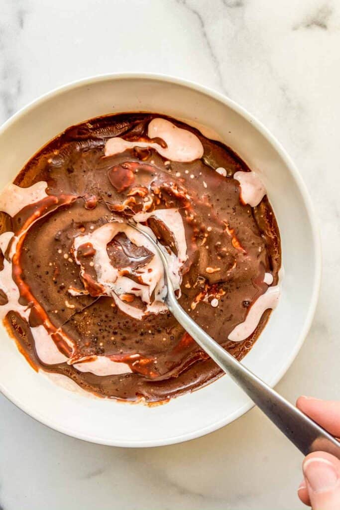 An overhead shot of a magic shell smoothie bowl with a silver spoon.