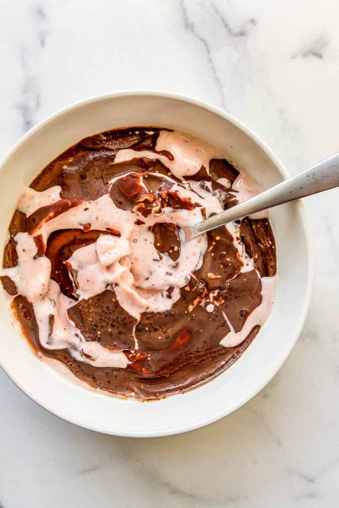 An overhead shot of a magic shell smoothie bowl with a silver spoon.