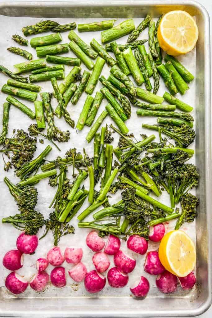 A sheet pan with roasted asparagus, broccolini, and radishes. 