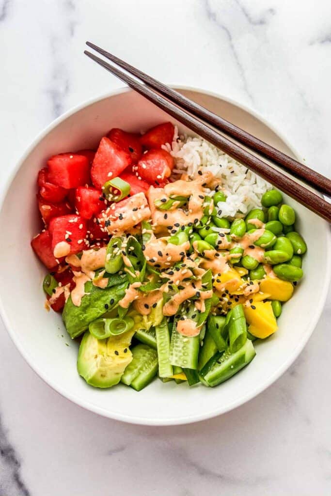 An overhead shot of a bowl of watermelon poke with chopsticks resting on the bowl.