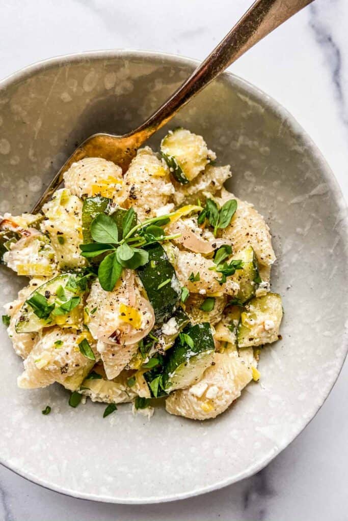 A bowl of feta, zucchini, and leek pasta.